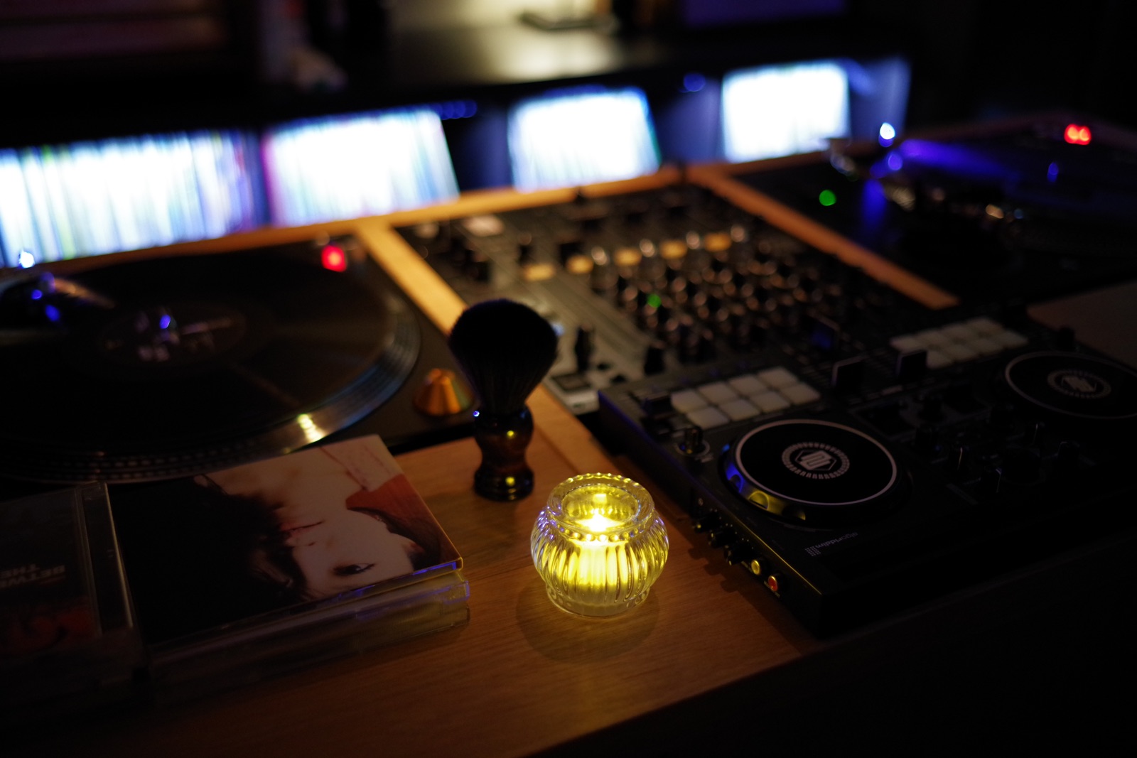 柔らかな灯りに照らされたレコードと音響機材